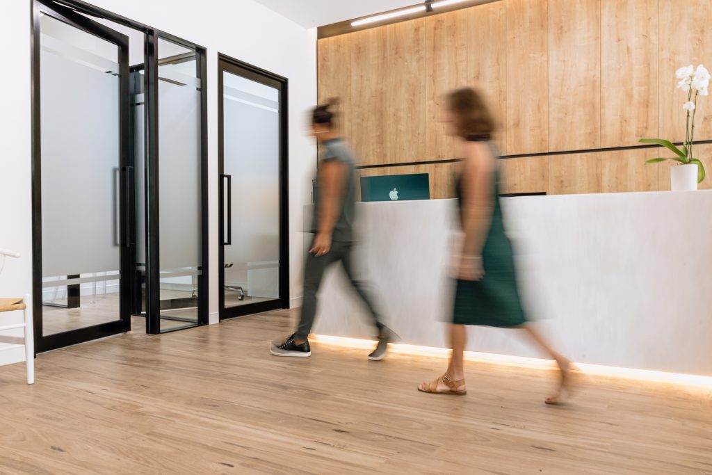 Modern reception area at Noosa Hinterland Dental with staff walking past the front desk