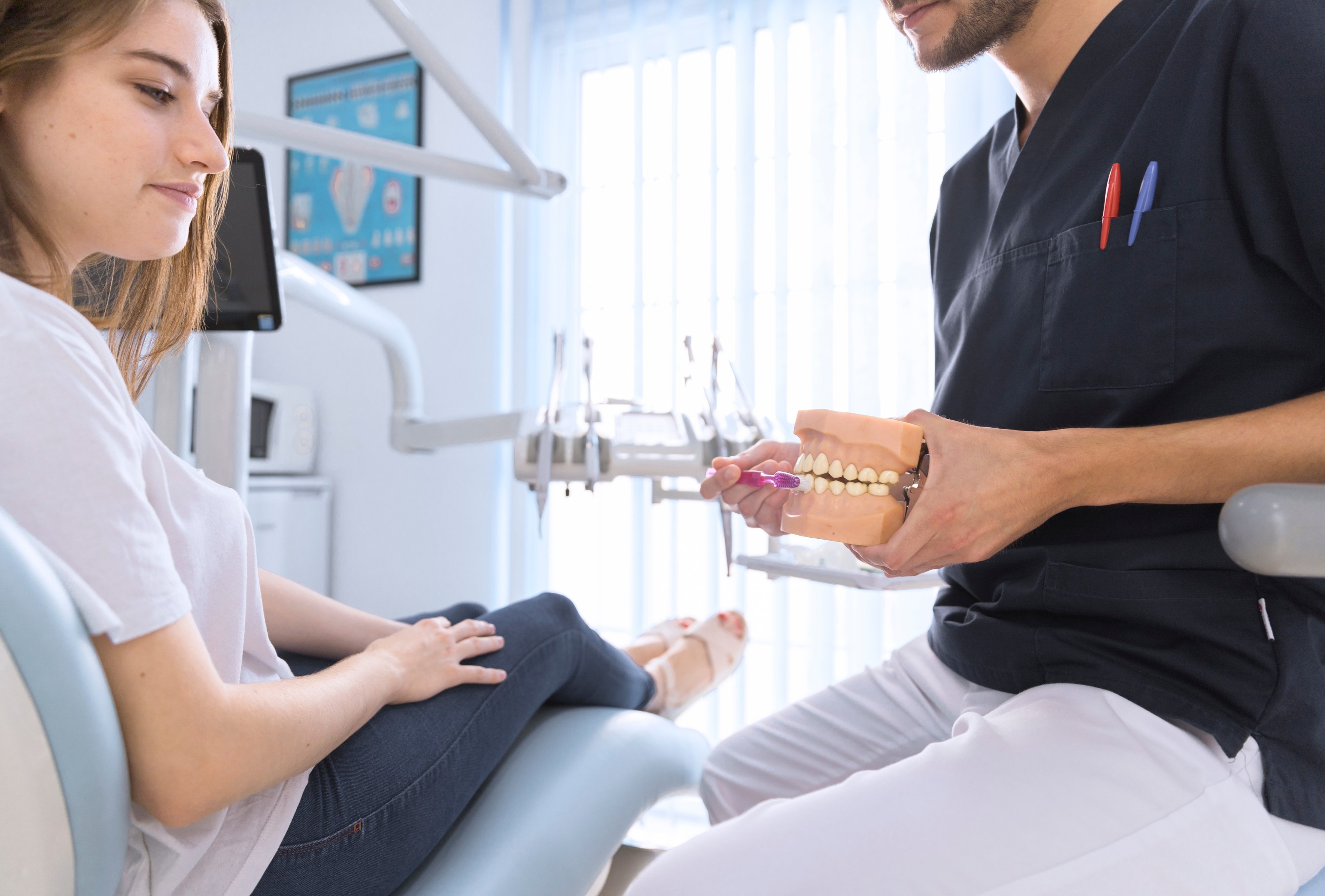 Dentist showing a dental model to a female patient during a consultation at our Sunshine Coast practice.