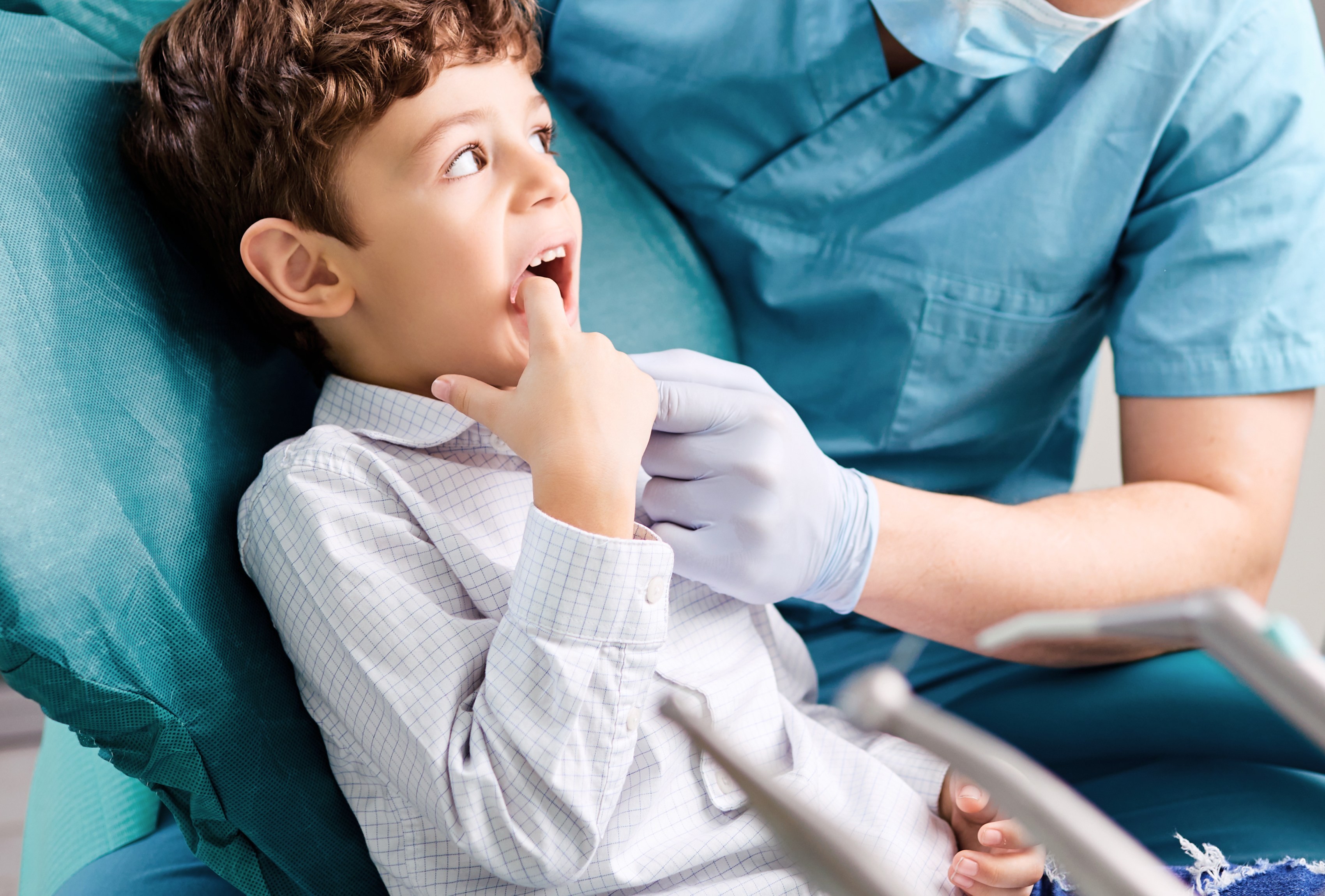 Young boy at the dentist pointing to his tooth during a dental check-up at our Sunshine Coast clinic.
