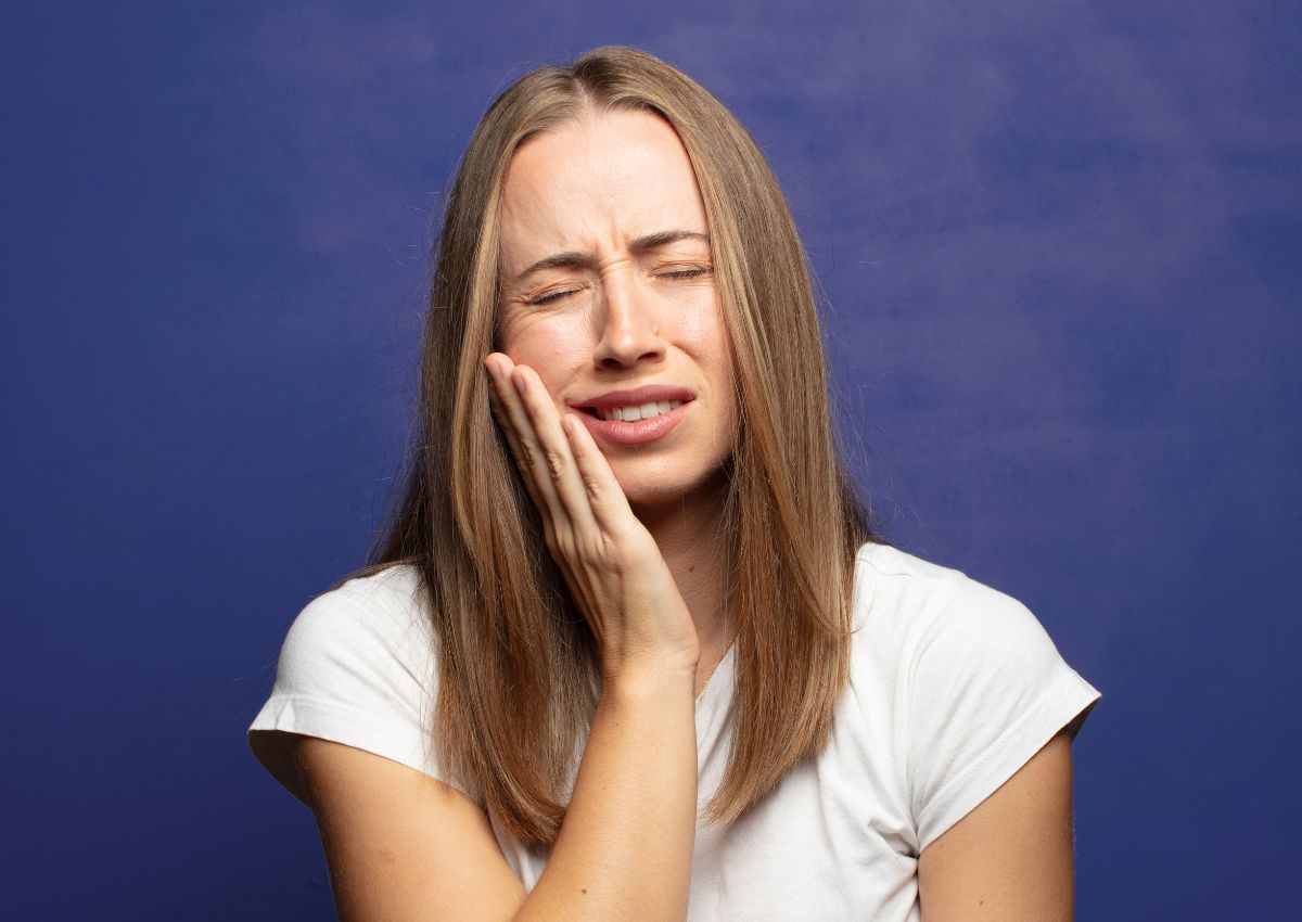 Woman experiencing toothache and jaw pain from tooth sensitivity